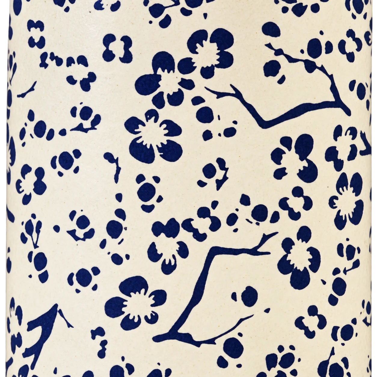 Gros plan sur un papier crème translucide orné de fleurs de cerisier et de branches bleu marine.