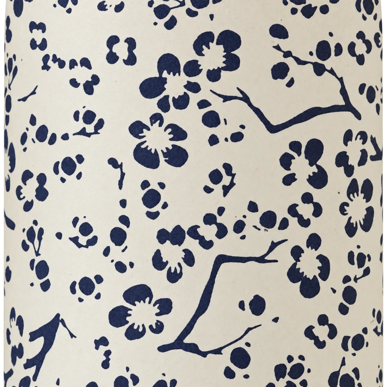 Gros plan sur un papier crème décoré de fleurs de cerisier et de branches bleu marine.