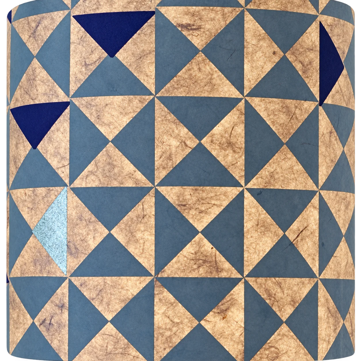 Gros plan sur un papier texturé orné d'un motif de triangles gris-bleu, avec quelques triangles bleu foncé et un triangle argenté.