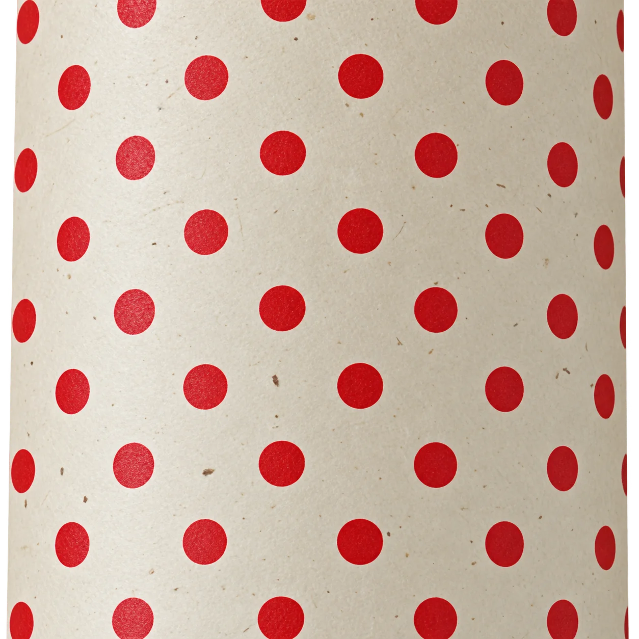 Gros plan sur un papier beige texturé orné de pois rouges régulièrement espacés.